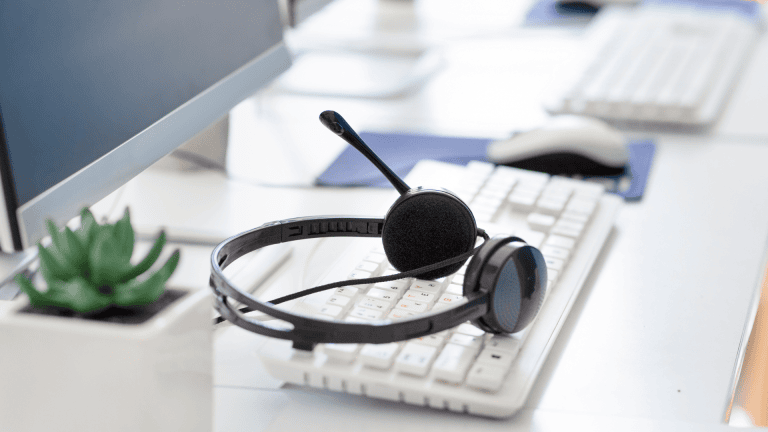 a pair of headphones sits on a desk next to a computer