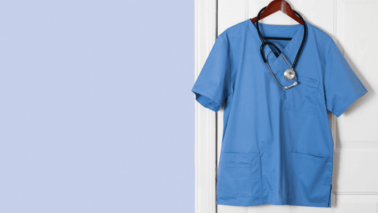 a blue scrub shirt hanging on a door