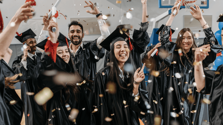 A group of graduates celebrating with confetti