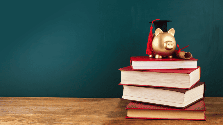 a piggy bank sitting on top of a stack of books
