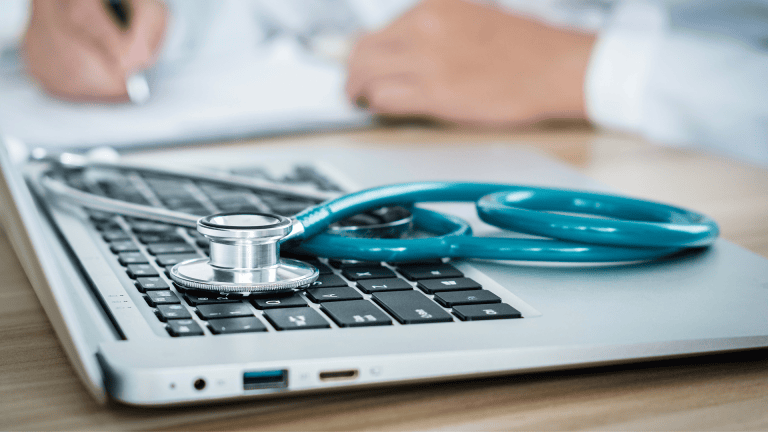 a laptop with a stethoscope sitting on top of it