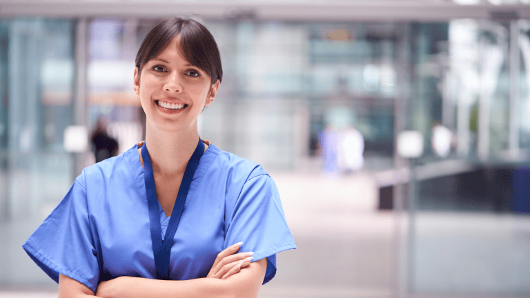 A person in scrubs standing in front of an office building