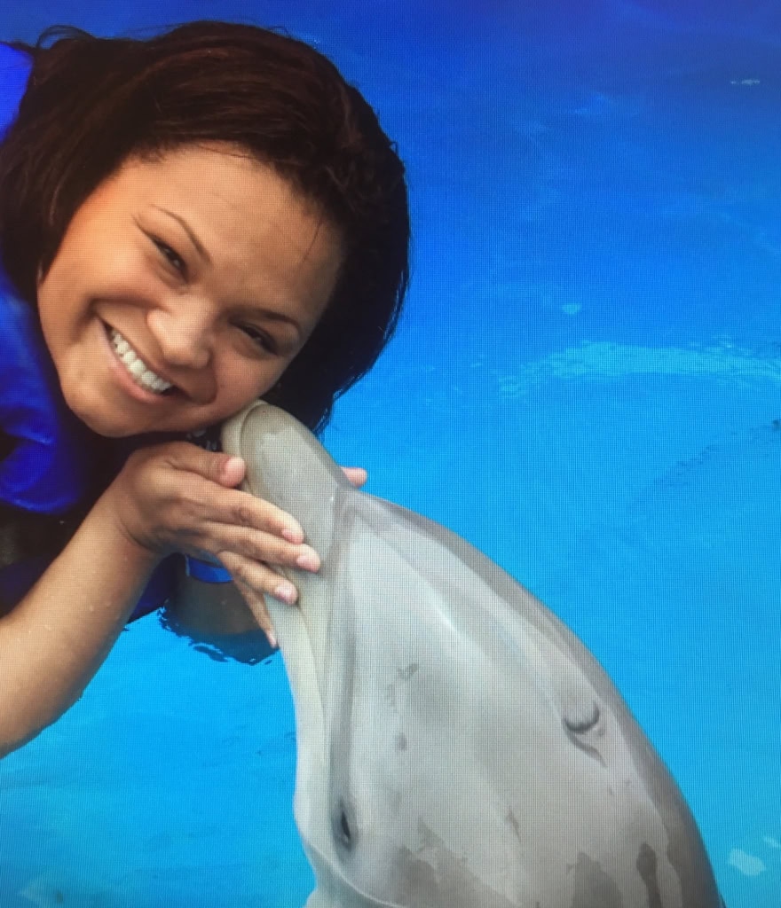 A smiling woman with a dolphin