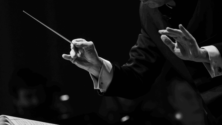a black and white photo of an orchestra conductor