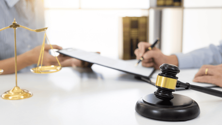 Two people working in front of a gavel and scales