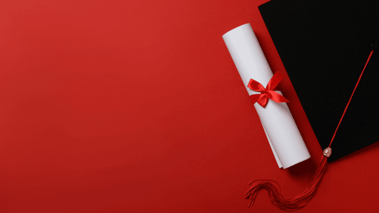 a graduation cap with a red ribbon on a red background